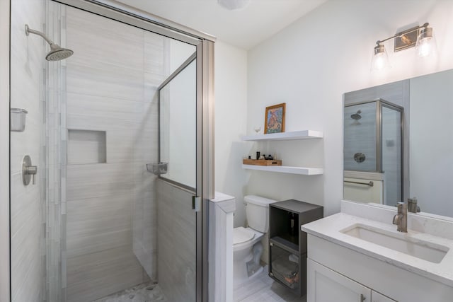 bathroom with a shower with door, vanity, and toilet