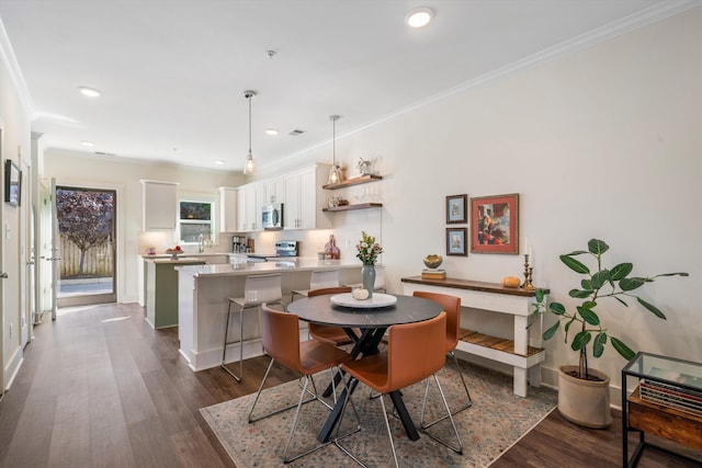 dining area with sink, crown molding, and dark wood-type flooring