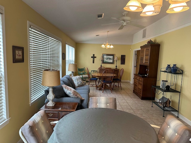 tiled living room featuring ceiling fan with notable chandelier and vaulted ceiling