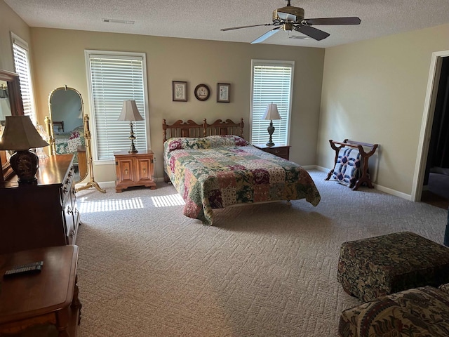 bedroom featuring multiple windows, light colored carpet, and a textured ceiling