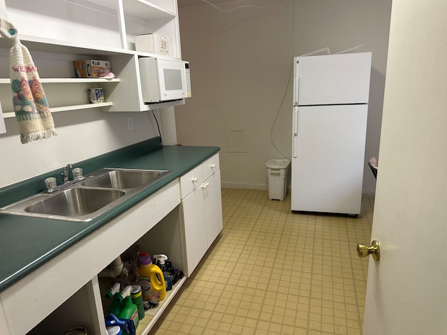 kitchen with sink, white cabinets, and white appliances