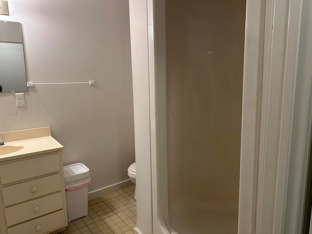 bathroom with walk in shower, vanity, and toilet