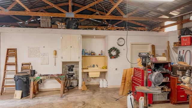 interior space with vaulted ceiling, sink, concrete floors, and a workshop area