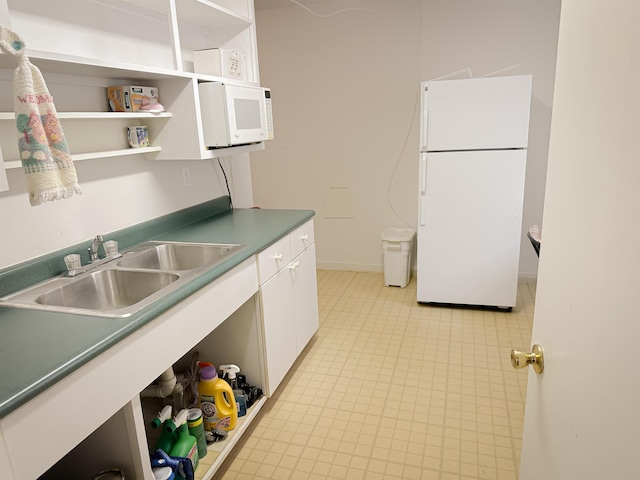 kitchen with sink, white cabinets, and white appliances