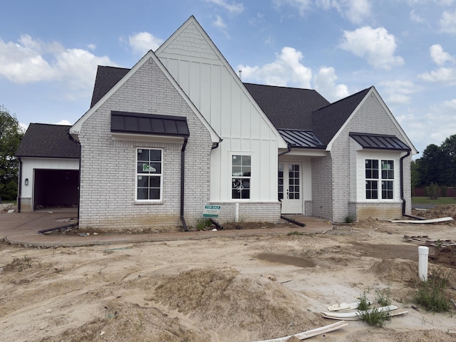 6284 Bevan Lake Dr, Arlington, TN 38002 - modern inspired farmhouse with a standing seam roof, french doors, board and batten siding, an attached garage, and metal roof