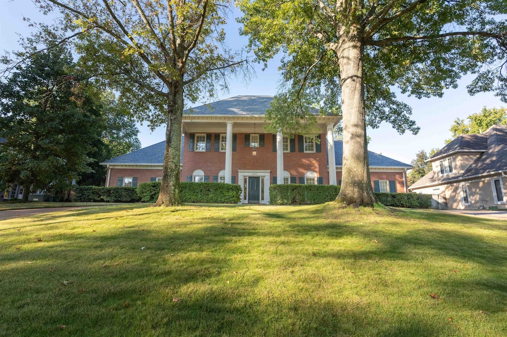 greek revival inspired property featuring a front yard