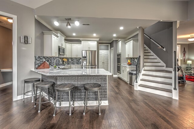 kitchen featuring stainless steel appliances, kitchen peninsula, dark hardwood / wood-style floors, decorative backsplash, and white cabinets