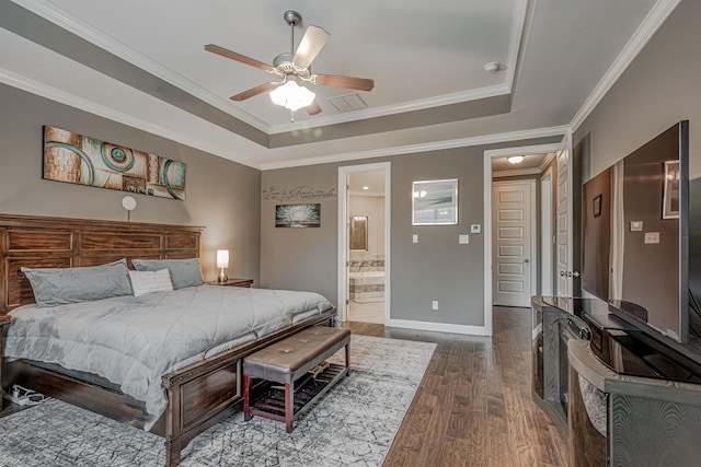 bedroom with ensuite bathroom, ceiling fan, ornamental molding, dark hardwood / wood-style flooring, and a tray ceiling