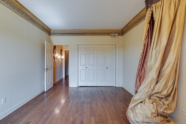 unfurnished bedroom with baseboards, visible vents, ornamental molding, and dark wood-type flooring
