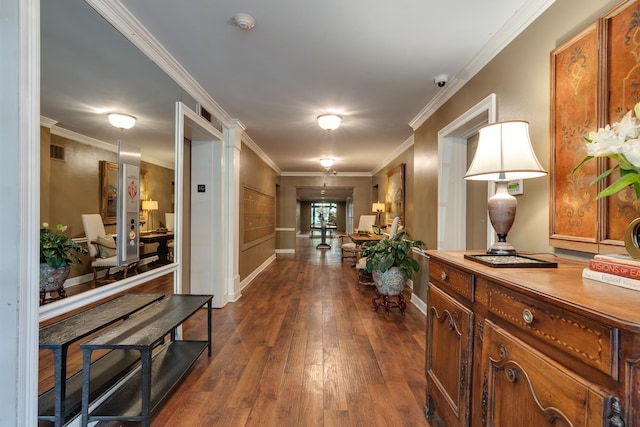 corridor with dark wood-style floors, visible vents, ornamental molding, and baseboards