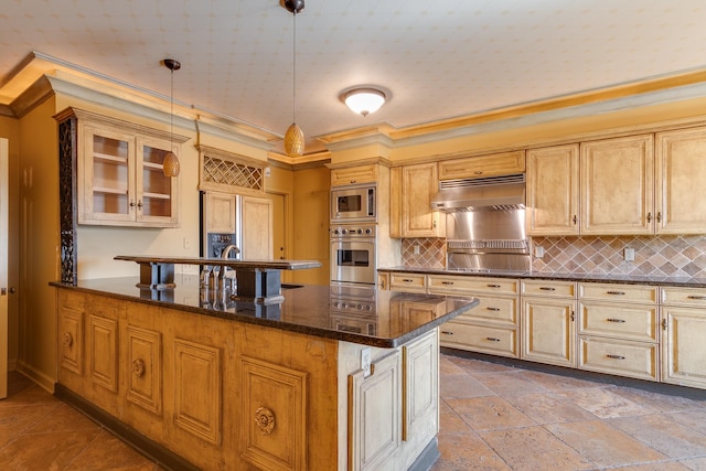 kitchen featuring decorative light fixtures, appliances with stainless steel finishes, dark stone counters, decorative backsplash, and exhaust hood