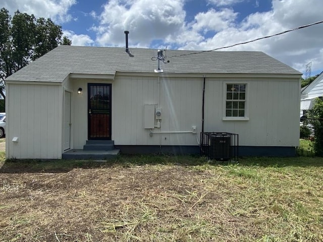 back of property featuring central AC unit and a lawn