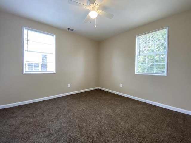 carpeted spare room featuring ceiling fan and a healthy amount of sunlight