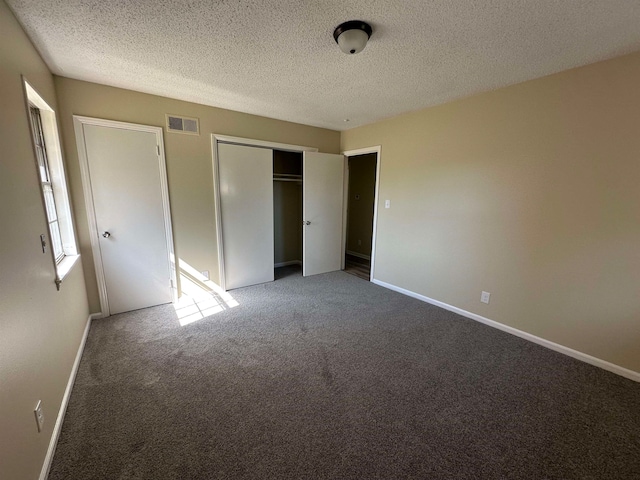 unfurnished bedroom with a textured ceiling and carpet