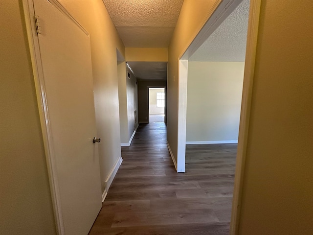 corridor featuring a textured ceiling and hardwood / wood-style flooring