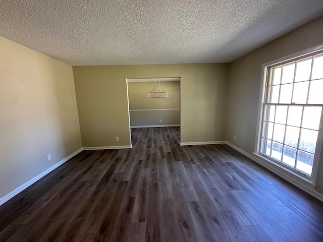 spare room with dark wood-type flooring and a textured ceiling