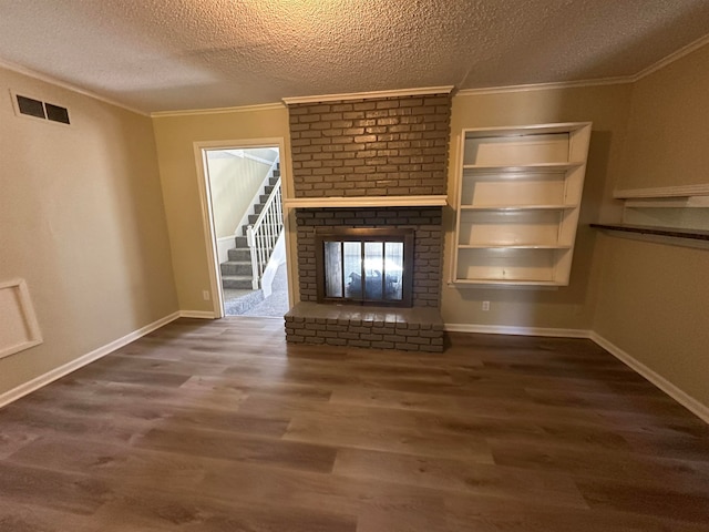 unfurnished living room with ornamental molding, a textured ceiling, a fireplace, and dark hardwood / wood-style flooring