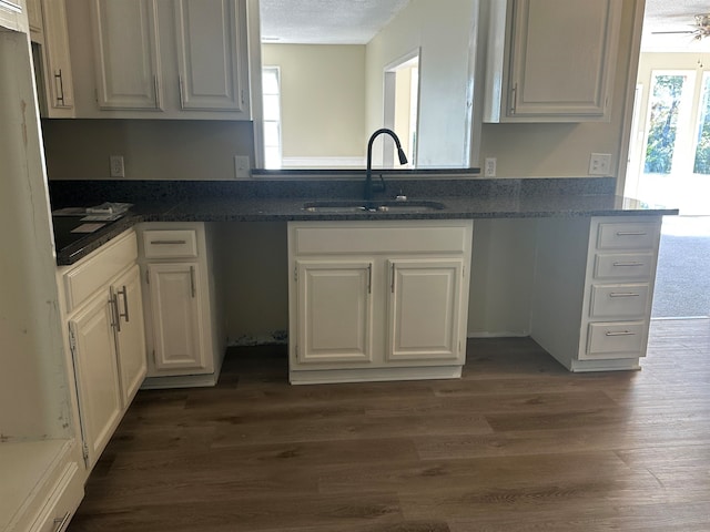 kitchen with white cabinets, a textured ceiling, and dark hardwood / wood-style flooring