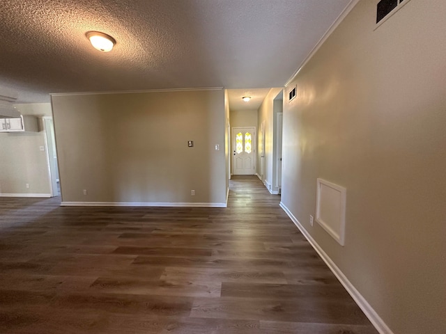 spare room featuring a textured ceiling, crown molding, and dark hardwood / wood-style floors