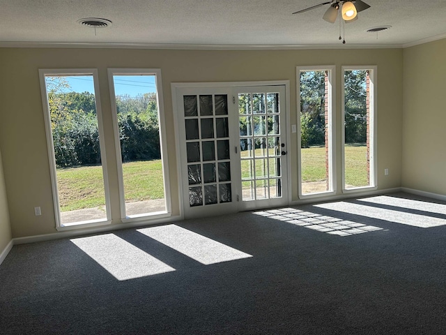 interior space with a textured ceiling, carpet flooring, and a wealth of natural light