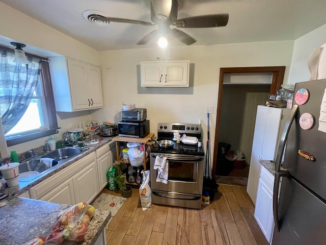 kitchen with sink, hardwood / wood-style floors, white cabinetry, appliances with stainless steel finishes, and ceiling fan