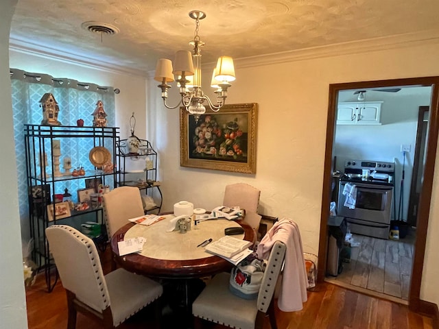 dining space with crown molding, a notable chandelier, a textured ceiling, and hardwood / wood-style floors