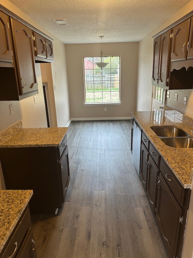 kitchen featuring dark hardwood / wood-style flooring, dark brown cabinetry, sink, dishwasher, and hanging light fixtures