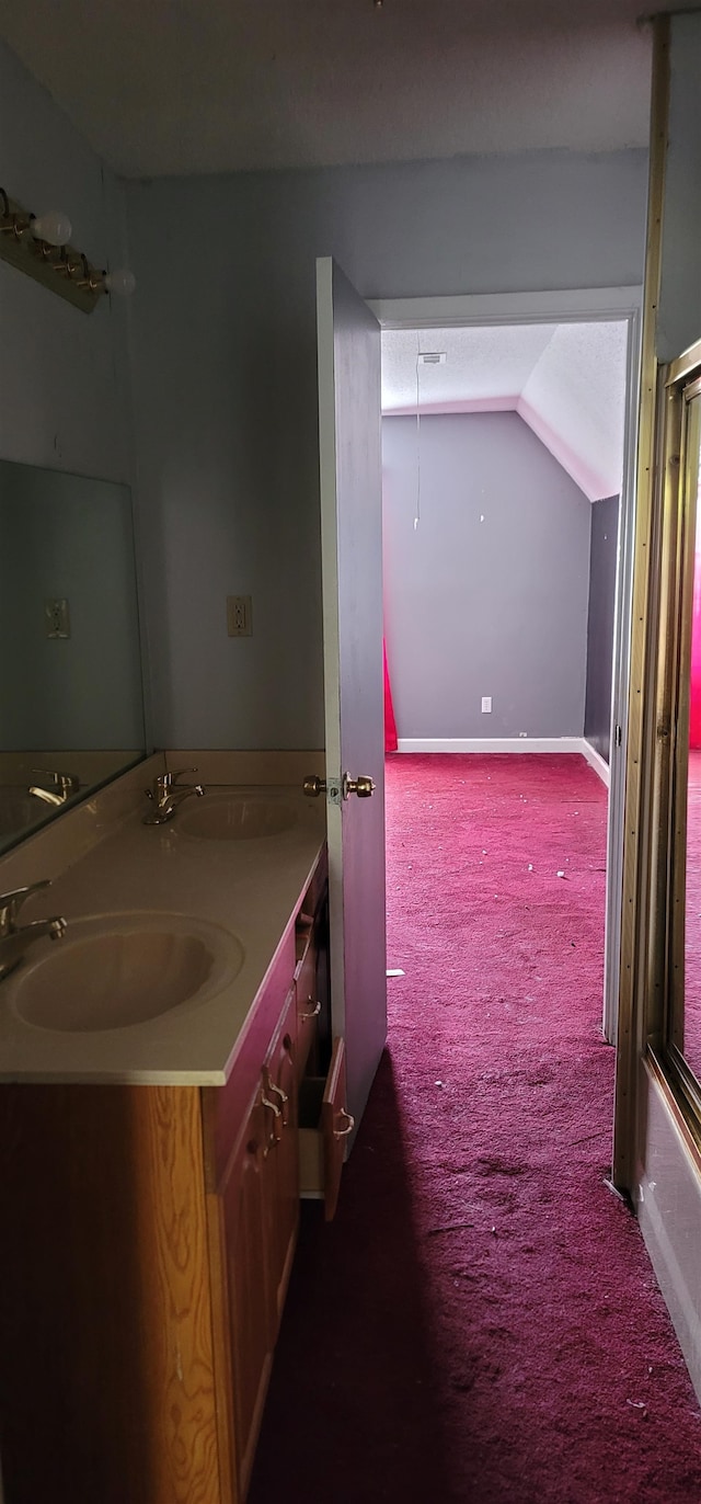 bathroom featuring vanity, enclosed tub / shower combo, and lofted ceiling