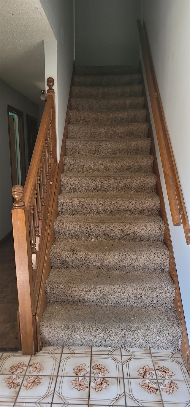 stairway with a textured ceiling