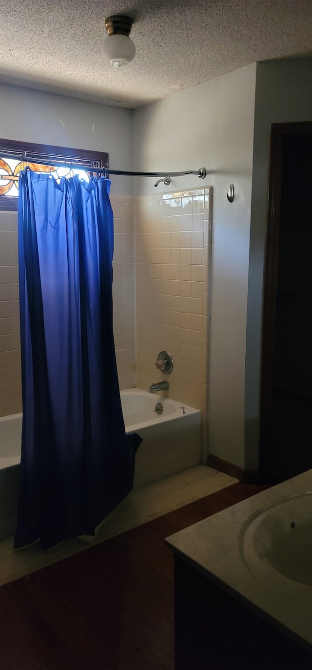 bathroom with vanity, a textured ceiling, and shower / tub combo with curtain