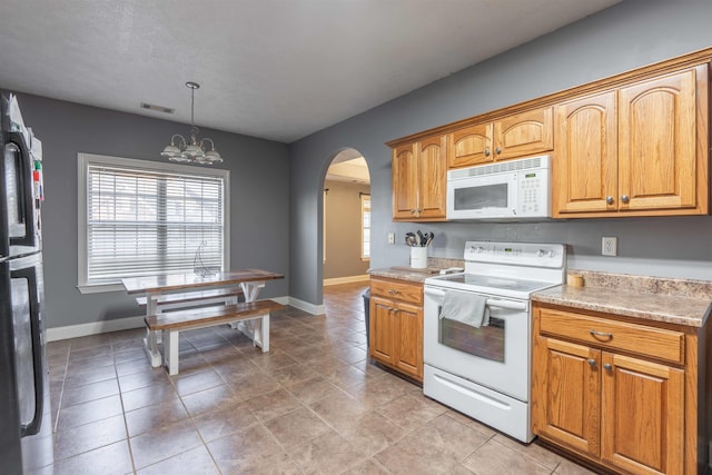 kitchen featuring pendant lighting, light tile patterned floors, white appliances, and a chandelier