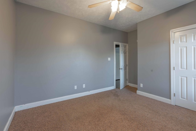 carpeted spare room with ceiling fan and a textured ceiling