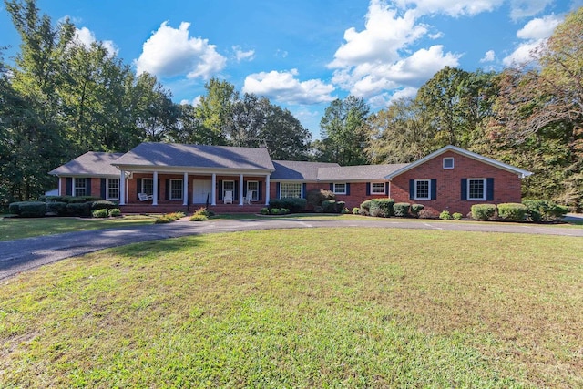 single story home with a front yard and covered porch