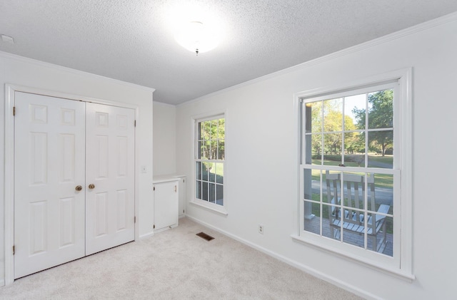 825 Barham Ln, Bolivar, TN 38008 - unfurnished bedroom featuring a textured ceiling, multiple windows, and light colored carpet