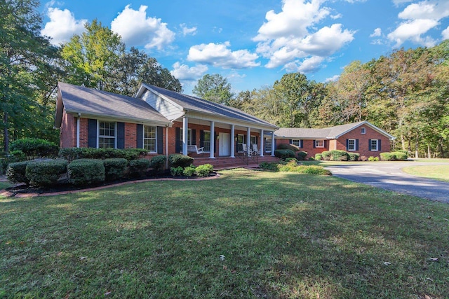 ranch-style house featuring a front yard and covered porch