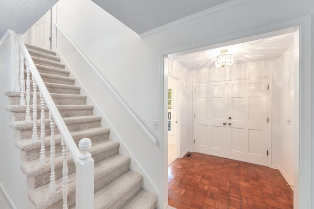 825 Barham Ln, Bolivar, TN 38008 - foyer entrance with crown molding, a textured ceiling, and dark parquet flooring