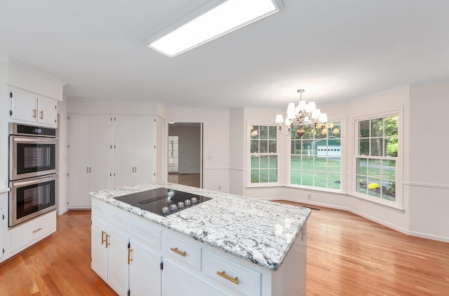 825 Barham Ln, Bolivar, TN 38008 - kitchen featuring a kitchen island, double oven, black electric cooktop, light hardwood / wood-style floors, and a notable chandelier