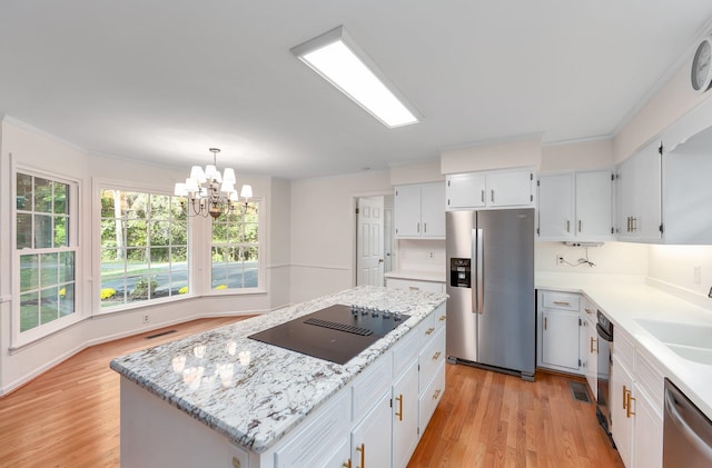 825 Barham Ln, Bolivar, TN 38008 - kitchen featuring white cabinets, appliances with stainless steel finishes, a chandelier, light hardwood / wood-style floors, and a center island
