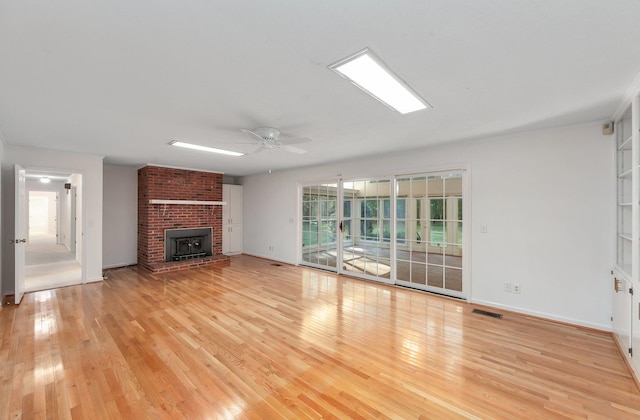 825 Barham Ln, Bolivar, TN 38008 - unfurnished living room featuring light hardwood / wood-style flooring, a wood stove, and ceiling fan