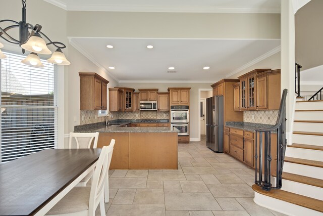 kitchen featuring kitchen peninsula, ornamental molding, tasteful backsplash, and stainless steel appliances