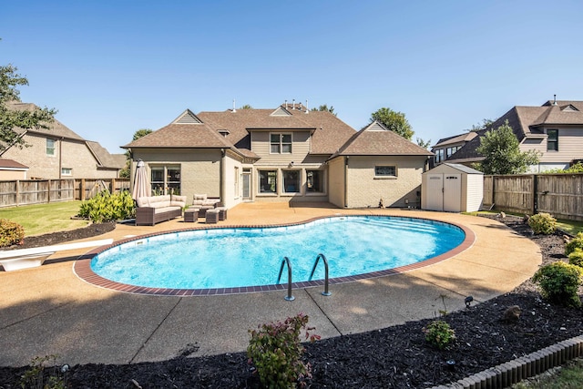 view of swimming pool featuring a patio, a storage unit, a diving board, and an outdoor living space