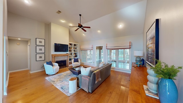 living room with light wood-type flooring, high vaulted ceiling, and ceiling fan