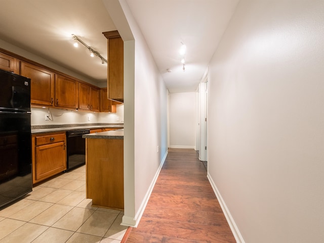 kitchen with light hardwood / wood-style floors, dishwasher, and rail lighting