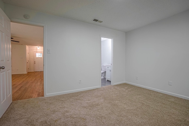 carpeted empty room with a textured ceiling