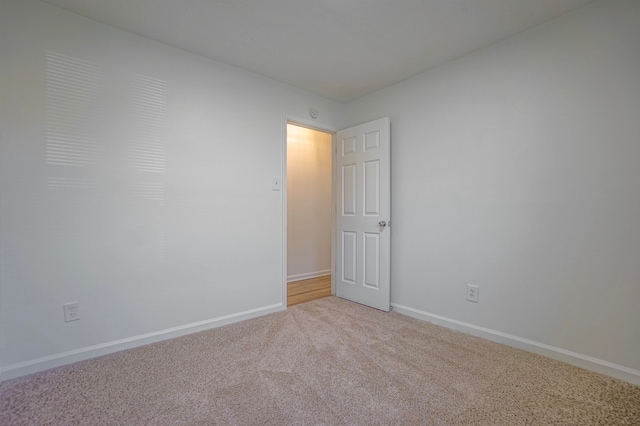 unfurnished room featuring light carpet