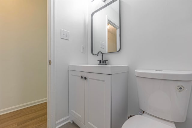 bathroom featuring toilet, hardwood / wood-style flooring, and vanity