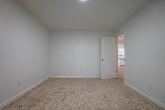 spare room featuring light colored carpet