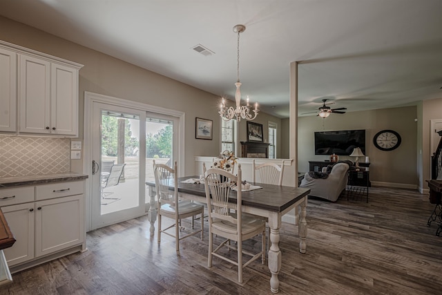 dining room featuring dark hardwood / wood-style flooring and ceiling fan with notable chandelier