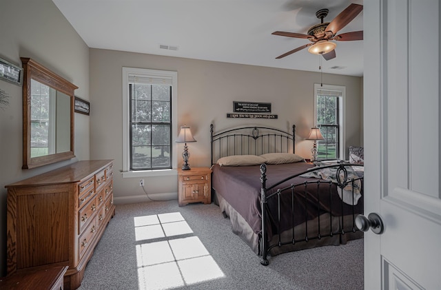 bedroom with ceiling fan, carpet flooring, and multiple windows