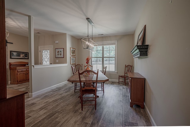 dining area with a notable chandelier and dark wood-type flooring